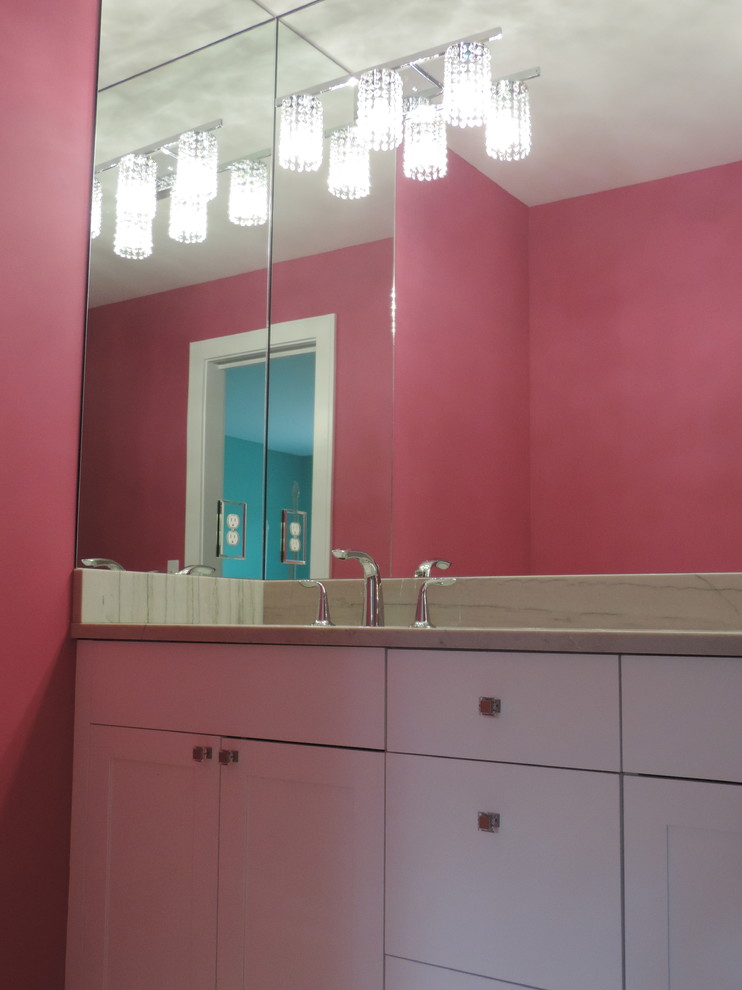 グランドラピッズにある中くらいなコンテンポラリースタイルのおしゃれな子供用バスルーム (アンダーカウンター洗面器、落し込みパネル扉のキャビネット、白いキャビネット、珪岩の洗面台、ピンクの壁) の写真