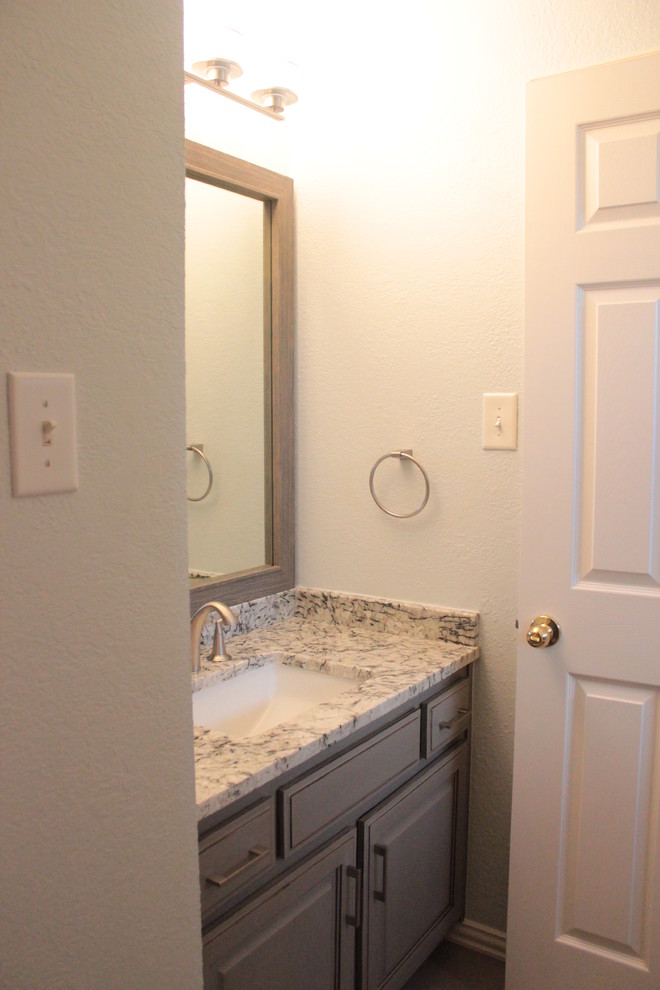 Esempio di una stanza da bagno con doccia moderna di medie dimensioni con ante lisce, top in marmo, ante grigie, doccia aperta, piastrelle grigie e lavabo da incasso