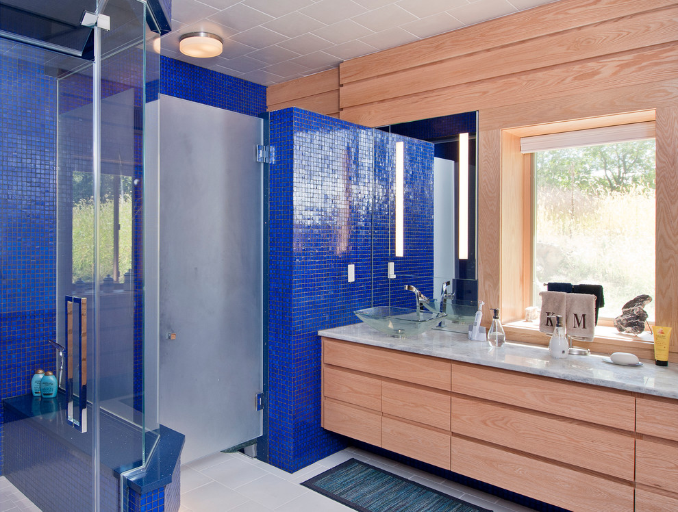 Ispirazione per una stanza da bagno minimal con lavabo a bacinella, ante lisce, ante in legno scuro, doccia ad angolo e piastrelle blu