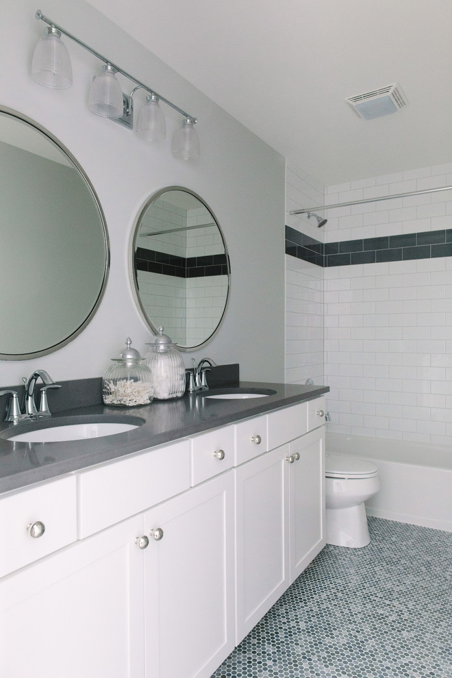 Пример оригинального дизайна: главная ванная комната среднего размера в современном стиле с фасадами в стиле шейкер, белыми фасадами, ванной в нише, душем над ванной, черно-белой плиткой, плиткой кабанчик, серыми стенами, полом из керамогранита, врезной раковиной и столешницей из искусственного кварца