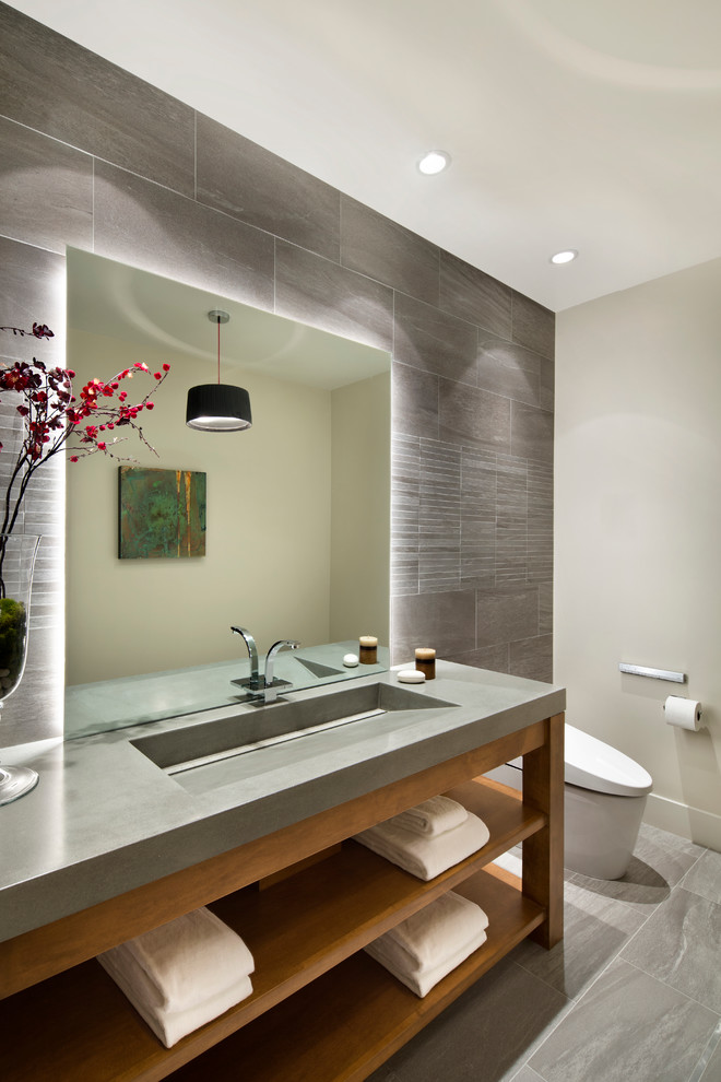 На фото: большая ванная комната в современном стиле с открытыми фасадами, унитазом-моноблоком, серой плиткой, серыми стенами, монолитной раковиной и столешницей из бетона с