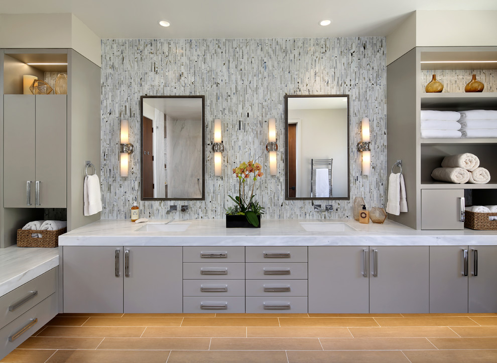 Ejemplo de cuarto de baño principal contemporáneo con armarios con paneles lisos, puertas de armario grises, baldosas y/o azulejos multicolor, lavabo bajoencimera y bañera exenta