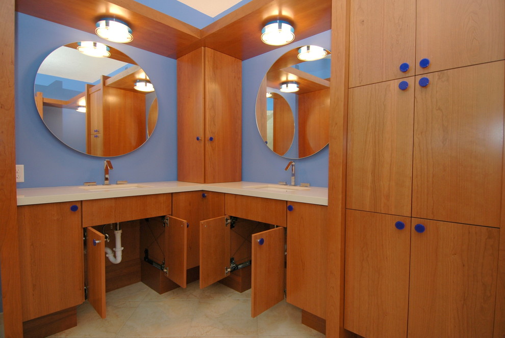 ミネアポリスにある広いコンテンポラリースタイルのおしゃれなマスターバスルーム (フラットパネル扉のキャビネット、中間色木目調キャビネット、ドロップイン型浴槽、バリアフリー、分離型トイレ、ベージュのタイル、セラミックタイル、青い壁、セラミックタイルの床、アンダーカウンター洗面器、クオーツストーンの洗面台) の写真