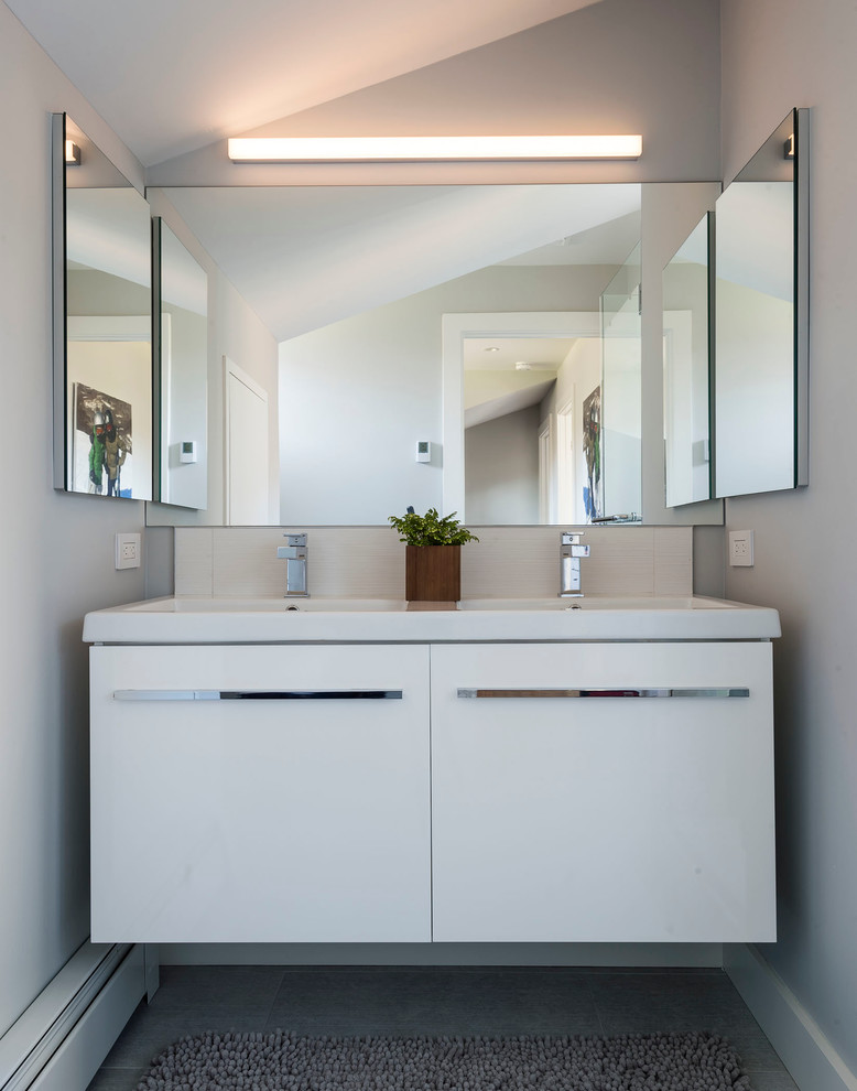 Photo of a small contemporary family bathroom in New York with flat-panel cabinets, white cabinets, a corner shower, grey tiles, porcelain tiles, grey walls, porcelain flooring, an integrated sink and solid surface worktops.