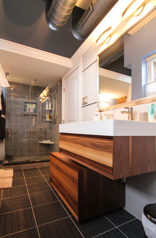 Inspiration för mellanstora moderna en-suite badrum, med ett integrerad handfat, skåp i mellenmörkt trä, blå väggar, ett fristående badkar och klinkergolv i porslin