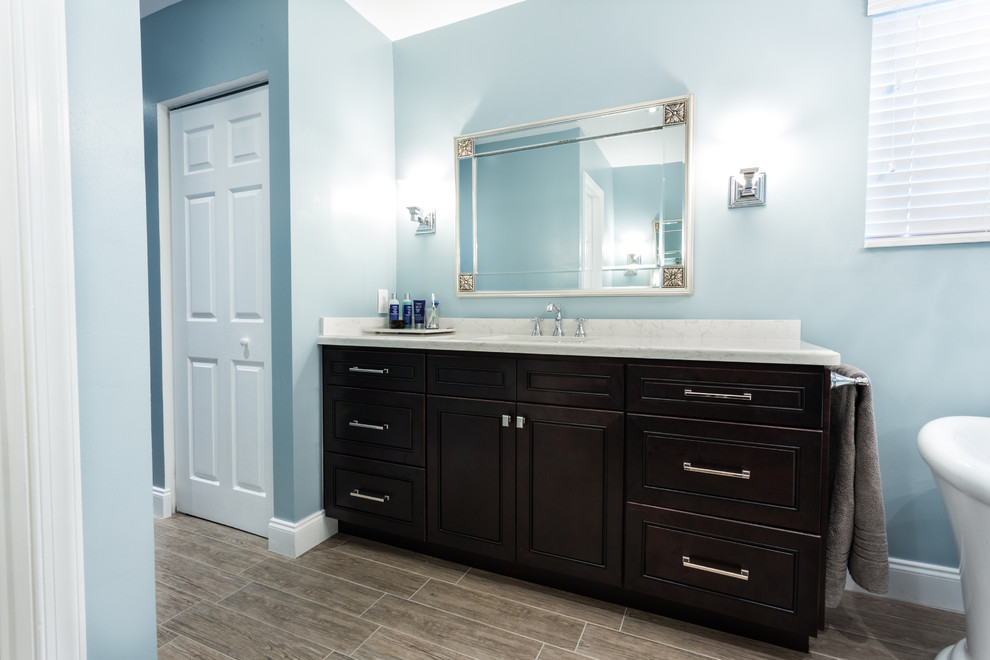 Large trendy master multicolored tile and porcelain tile porcelain tile bathroom photo in Miami with shaker cabinets, dark wood cabinets, quartz countertops, a one-piece toilet and blue walls