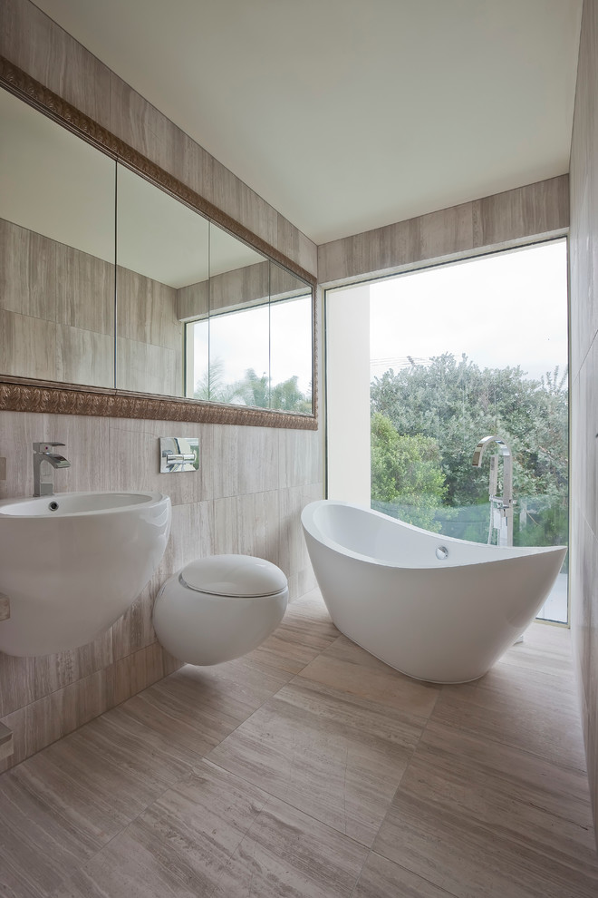Inspiration för moderna badrum, med ett fristående badkar, en vägghängd toalettstol och ett väggmonterat handfat