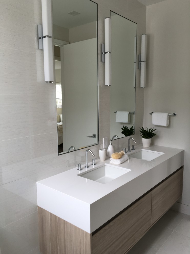 Modernes Badezimmer mit beiger Wandfarbe, Unterbauwaschbecken, beigem Boden, flächenbündigen Schrankfronten, hellen Holzschränken, Mineralwerkstoff-Waschtisch und weißer Waschtischplatte in San Francisco