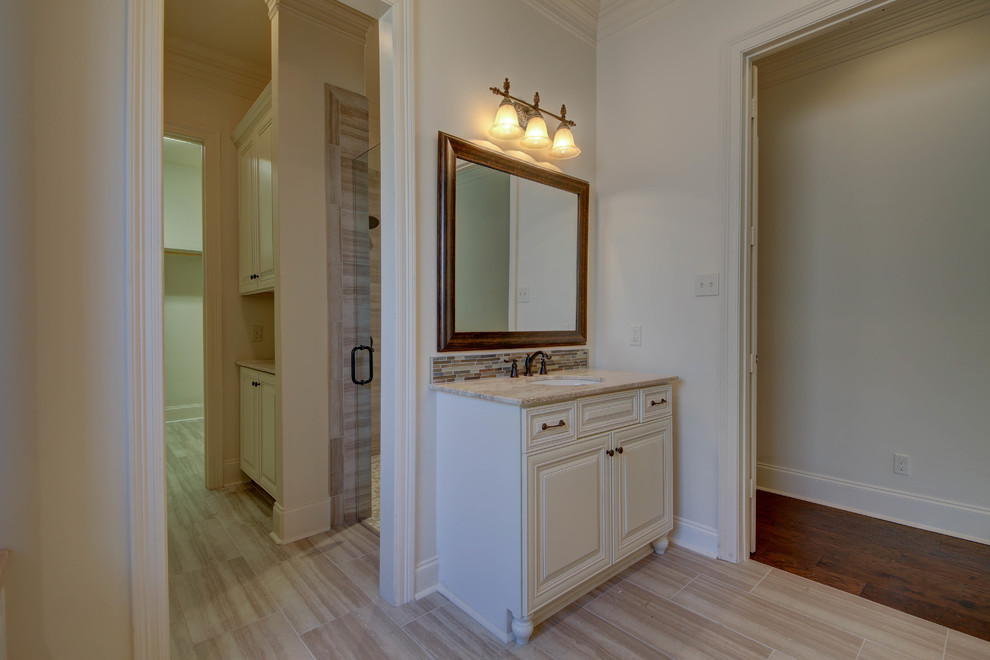 Bild på ett mellanstort vintage en-suite badrum, med luckor med upphöjd panel, vita skåp, ett badkar med tassar, beige kakel, brun kakel, stickkakel, vita väggar, klinkergolv i porslin och ett undermonterad handfat