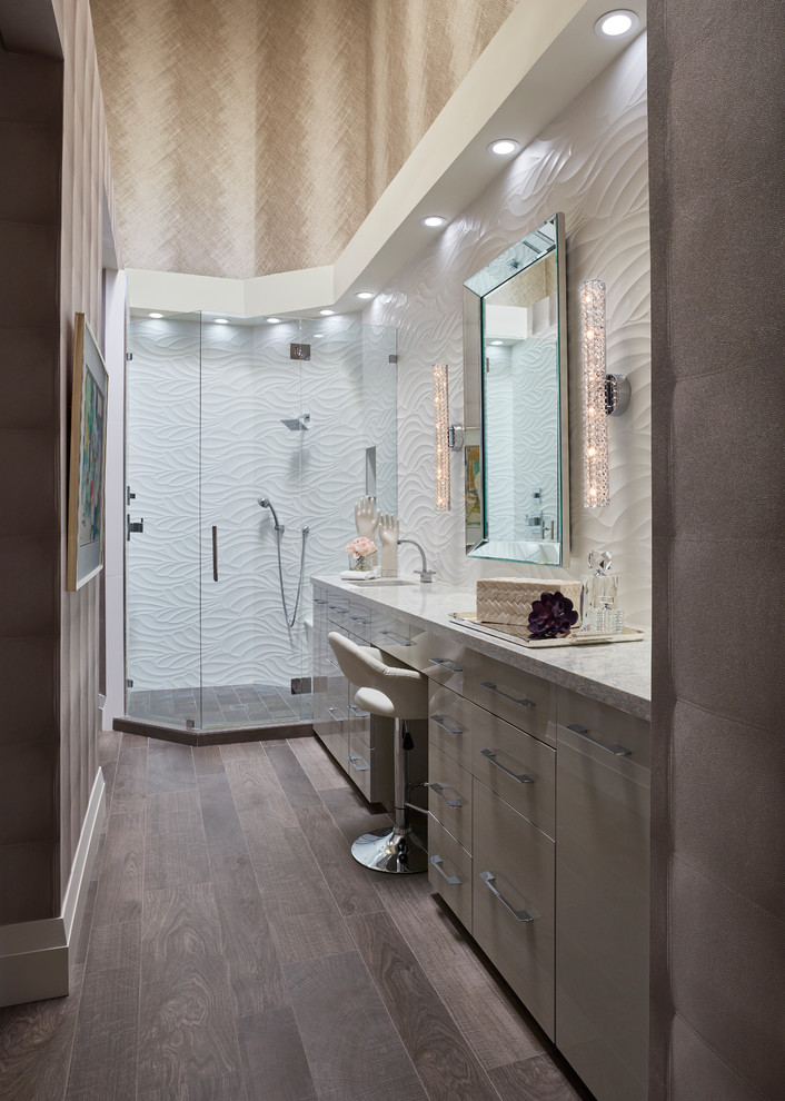 Mittelgroßes Modernes Badezimmer En Suite mit flächenbündigen Schrankfronten, beigen Schränken, Eckdusche, beiger Wandfarbe, dunklem Holzboden, Unterbauwaschbecken, braunem Boden, Falttür-Duschabtrennung und weißer Waschtischplatte in Miami