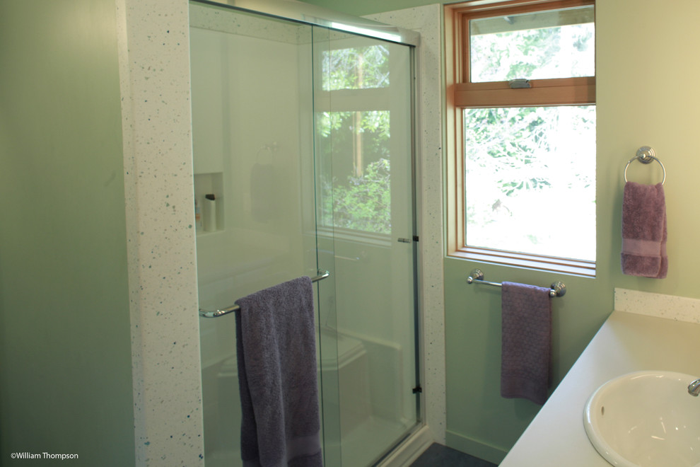 Exempel på ett mellanstort klassiskt grön grönt badrum för barn, med ett nedsänkt handfat, släta luckor, vita skåp, bänkskiva i akrylsten, en toalettstol med separat cisternkåpa, linoleumgolv, en dusch i en alkov, gröna väggar, blått golv och dusch med skjutdörr