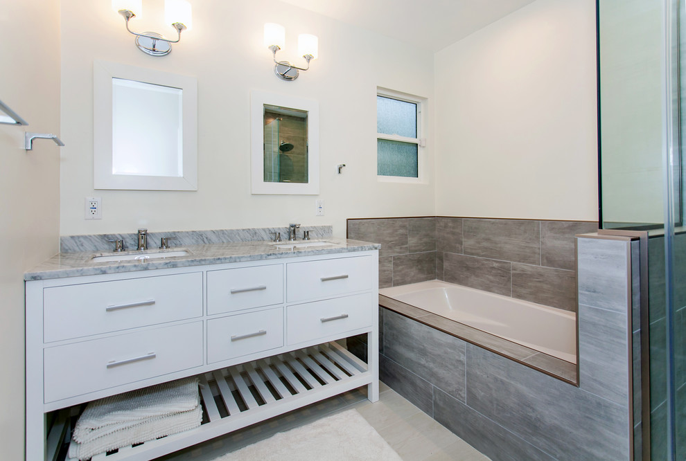 Idées déco pour une salle de bain principale contemporaine de taille moyenne avec un placard en trompe-l'oeil, des portes de placard blanches, une baignoire encastrée, une douche d'angle, WC à poser, un carrelage gris, des carreaux de porcelaine, un mur blanc, un sol en carrelage de porcelaine, un lavabo encastré, un plan de toilette en marbre et un sol gris.