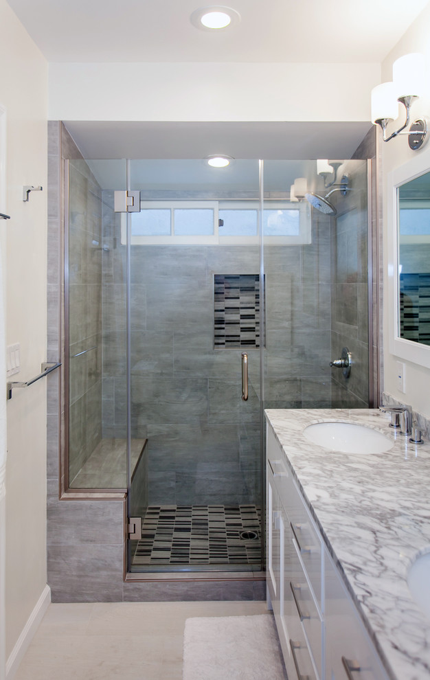 Exemple d'une salle de bain principale tendance de taille moyenne avec un placard en trompe-l'oeil, des portes de placard blanches, une baignoire encastrée, une douche d'angle, WC à poser, un carrelage gris, des carreaux de porcelaine, un mur blanc, un sol en carrelage de porcelaine, un lavabo encastré et un plan de toilette en marbre.