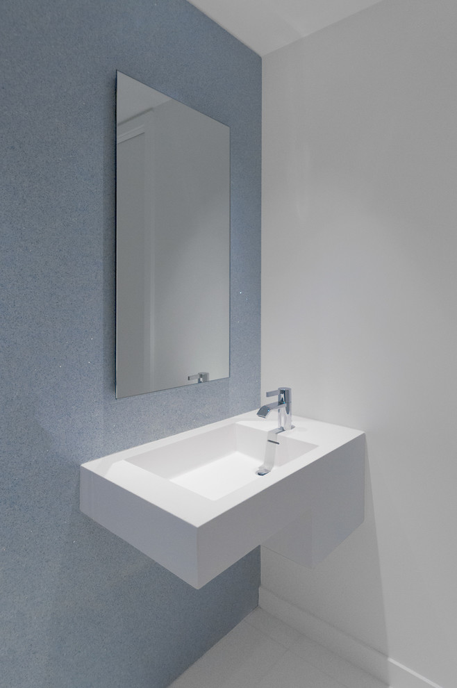 Foto di una stanza da bagno moderna con lavabo sospeso, piastrelle blu e piastrelle di cemento