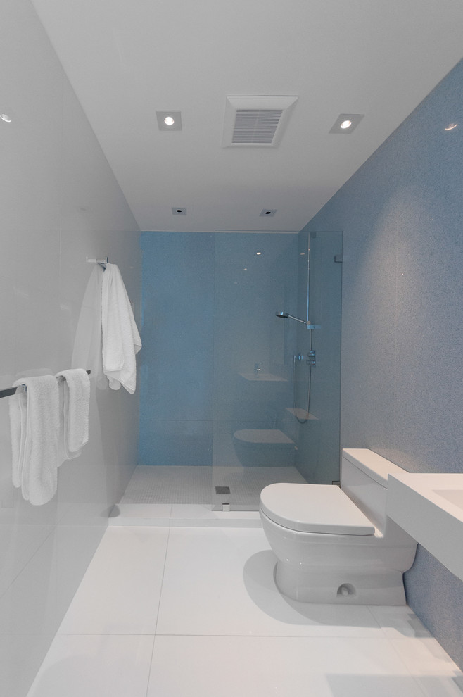 Aménagement d'une salle de bain moderne avec une douche ouverte, WC à poser, un carrelage noir et des dalles de pierre.