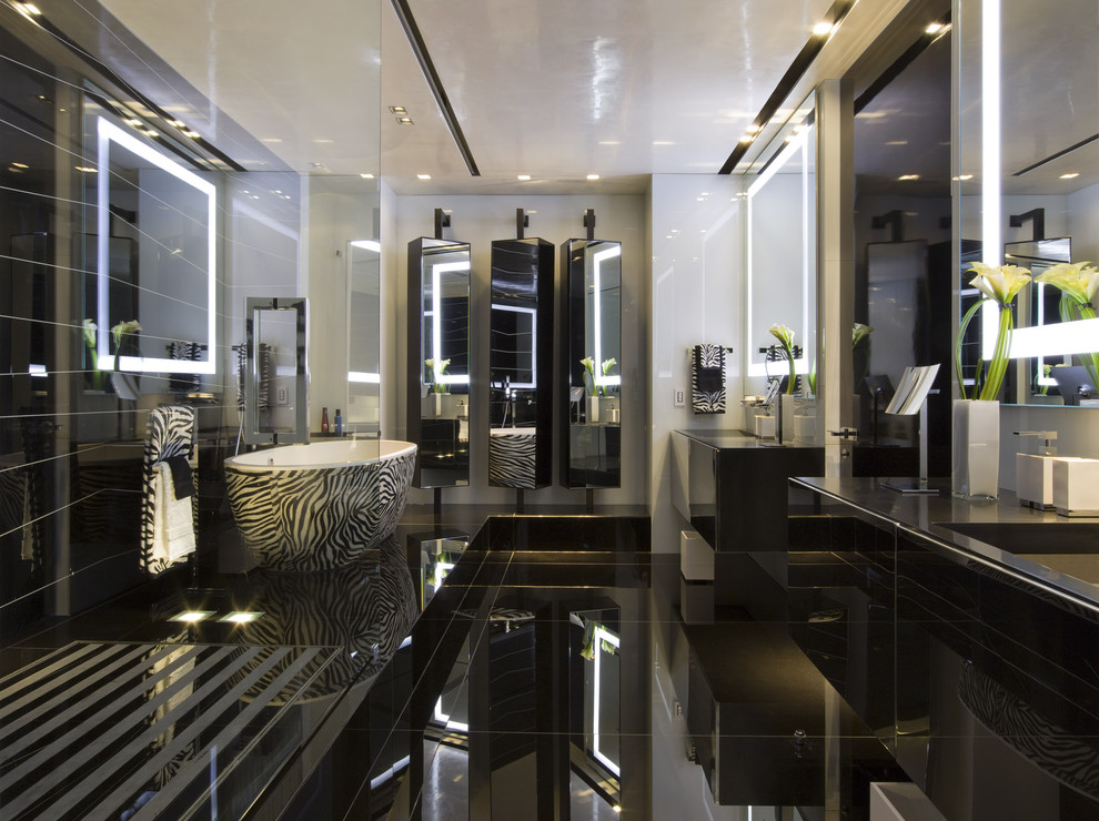 Ispirazione per una stanza da bagno minimalista con vasca freestanding e pavimento nero