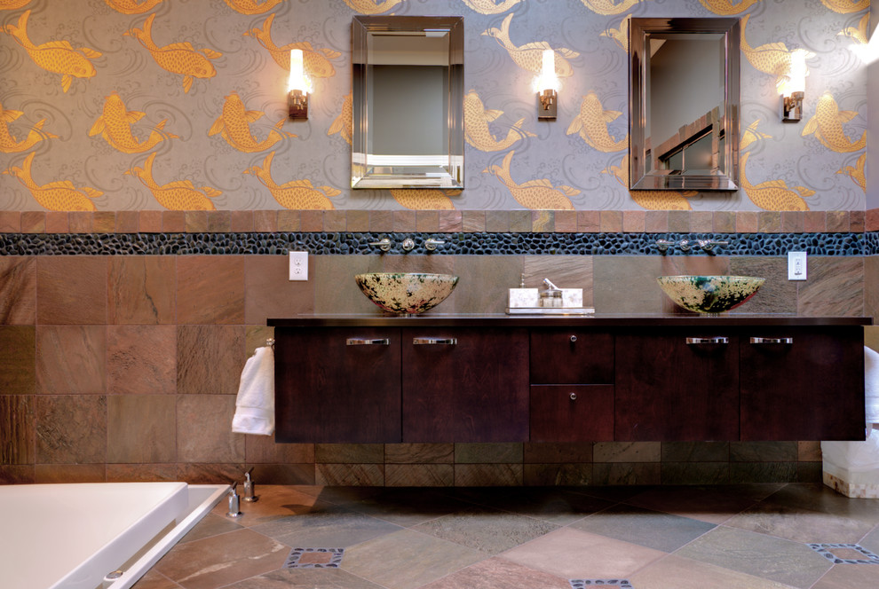 Imagen de cuarto de baño de estilo zen con lavabo sobreencimera, armarios con paneles lisos, puertas de armario de madera en tonos medios, baldosas y/o azulejos marrones y suelo de baldosas tipo guijarro