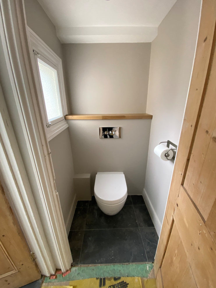 На фото: детская ванная комната среднего размера в современном стиле с коричневыми фасадами, душем над ванной, белой плиткой, полом из керамогранита, серым полом, тумбой под одну раковину и подвесной тумбой