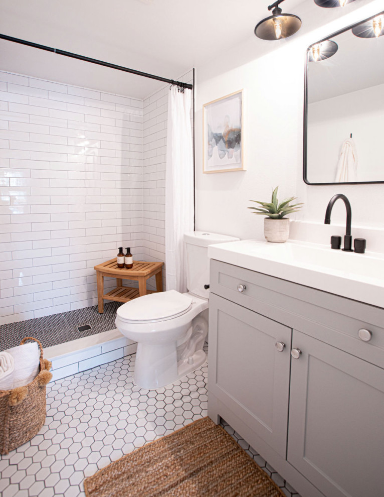 Idée de décoration pour une petite salle de bain principale champêtre avec des portes de placard grises, WC à poser, un carrelage blanc, des carreaux de porcelaine, un mur gris, un sol en carrelage de porcelaine, un plan de toilette en quartz, un sol blanc, une cabine de douche avec un rideau, un plan de toilette blanc, meuble simple vasque et meuble-lavabo sur pied.