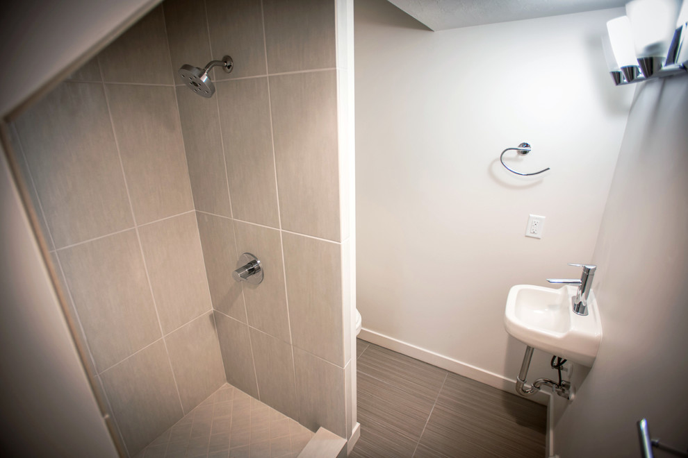 Immagine di una stanza da bagno minimalista con lavabo sospeso, doccia alcova, WC a due pezzi, piastrelle grigie e piastrelle in ceramica