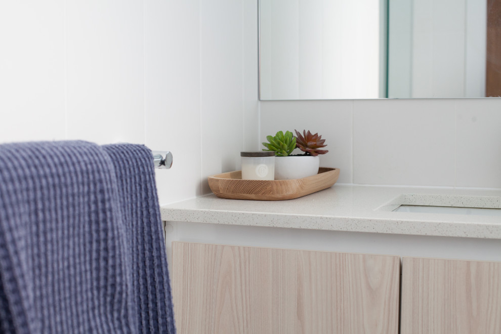 Kleines Modernes Badezimmer mit verzierten Schränken, beigen Schränken, Duschnische, Wandtoilette mit Spülkasten, weißen Fliesen, Porzellanfliesen, weißer Wandfarbe, Porzellan-Bodenfliesen, integriertem Waschbecken, Quarzwerkstein-Waschtisch, grauem Boden und Falttür-Duschabtrennung in Sydney
