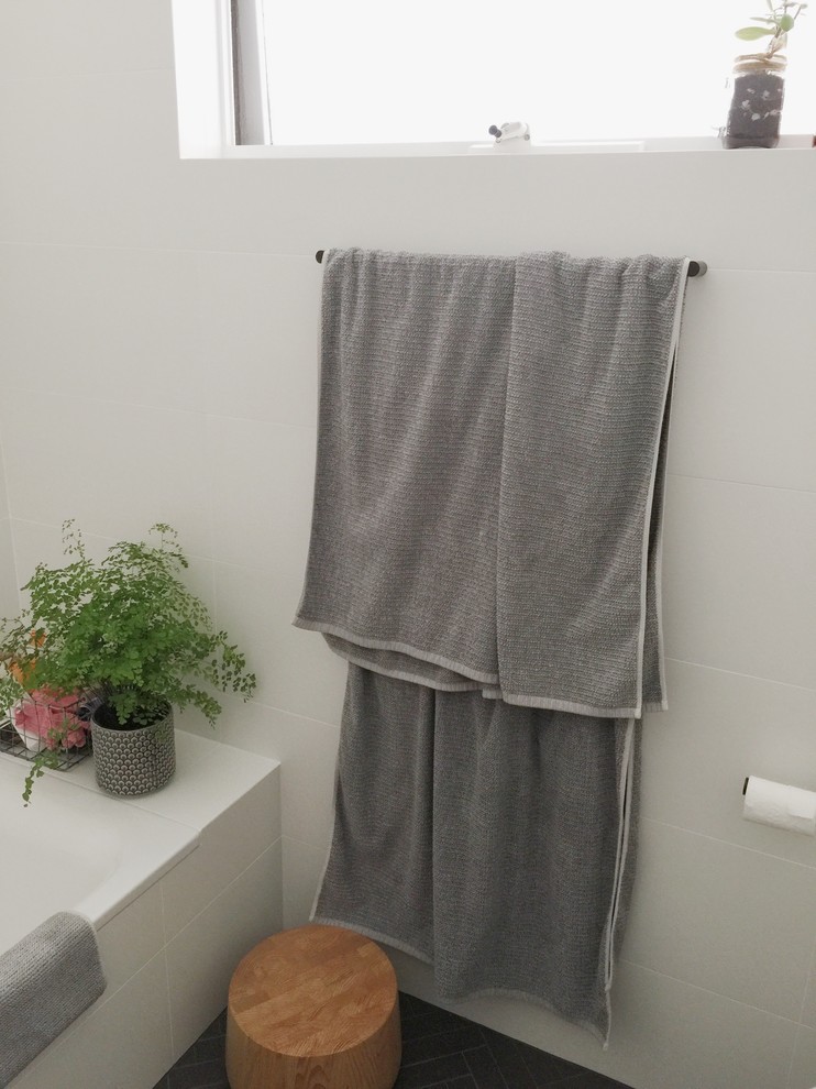 Design ideas for a small scandi bathroom in Sydney with light wood cabinets, a built-in bath, a shower/bath combination, a one-piece toilet, white tiles, ceramic tiles, white walls and an integrated sink.