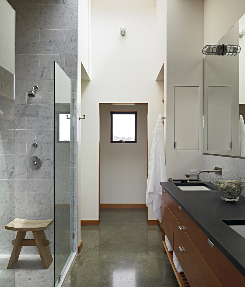 Esempio di una stanza da bagno contemporanea con lavabo sottopiano, ante lisce, ante in legno scuro, doccia aperta, piastrelle grigie, top in saponaria e pavimento in cemento