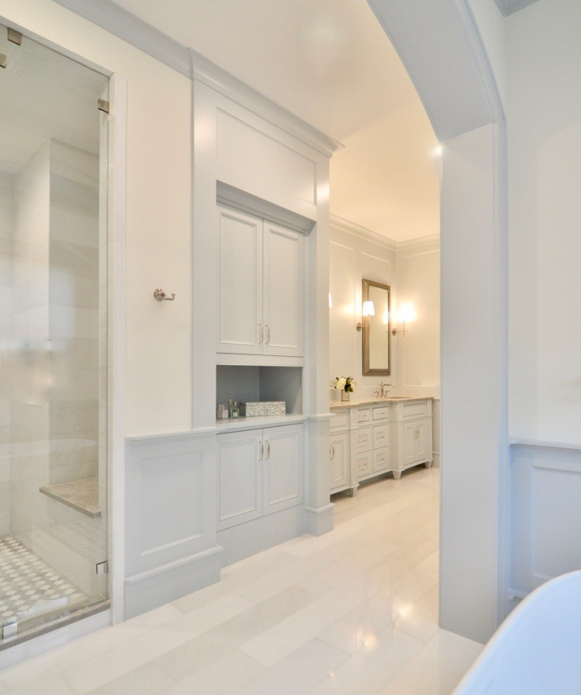 Idée de décoration pour une grande salle de bain principale tradition avec des portes de placard blanches, une baignoire indépendante, un carrelage blanc, un mur blanc, un sol blanc, une cabine de douche à porte battante et meuble-lavabo encastré.