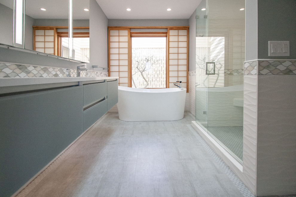 Immagine di una stanza da bagno padronale minimalista di medie dimensioni con ante blu, vasca freestanding, doccia alcova, piastrelle bianche, lavabo sottopiano, pavimento grigio e porta doccia a battente