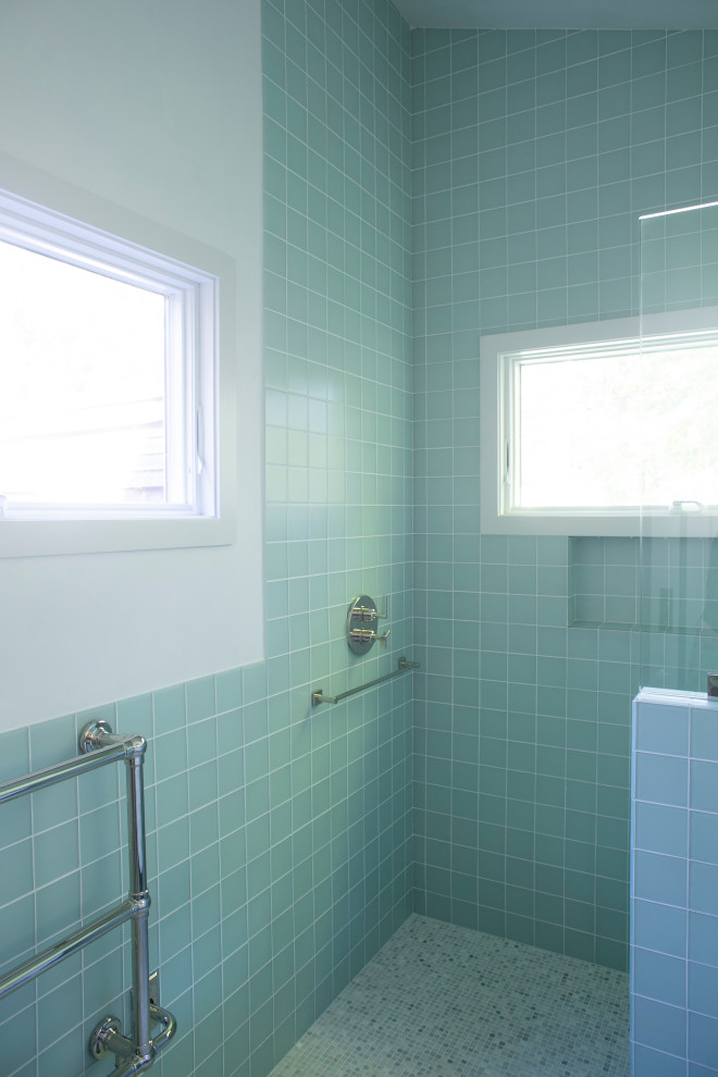 Inredning av ett maritimt mellanstort vit vitt badrum, med vita skåp, våtrum, blå kakel, glaskakel, vita väggar, klinkergolv i keramik, flerfärgat golv och med dusch som är öppen