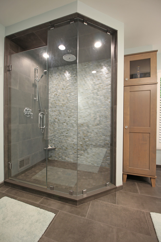Example of a mid-sized transitional master blue tile and glass tile porcelain tile and gray floor bathroom design in Detroit with shaker cabinets, medium tone wood cabinets, a two-piece toilet, blue walls, an undermount sink, quartz countertops, a hinged shower door and white countertops