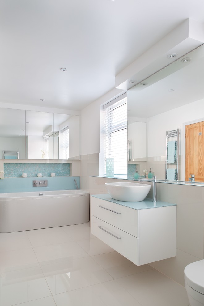 Immagine di una stanza da bagno design con vasca freestanding, doccia aperta, WC sospeso, piastrelle blu, piastrelle in gres porcellanato e pavimento in gres porcellanato