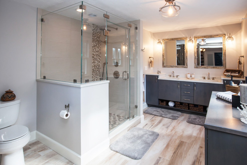 This is an example of a medium sized contemporary ensuite bathroom in Boston with flat-panel cabinets, grey cabinets, an alcove shower, a two-piece toilet, beige tiles, porcelain tiles, beige walls, porcelain flooring, a submerged sink and engineered stone worktops.