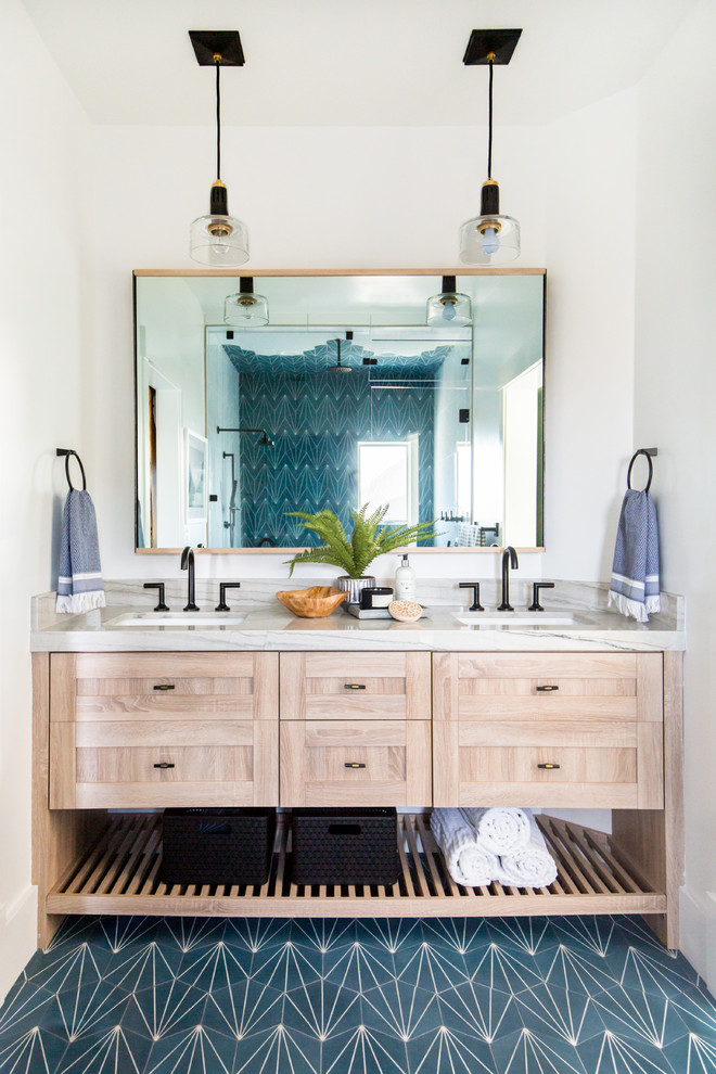 Réalisation d'une douche en alcôve design en bois clair avec un placard à porte shaker, un carrelage bleu, un carrelage blanc, un mur blanc, un lavabo encastré, un sol bleu, une cabine de douche à porte battante et un plan de toilette beige.