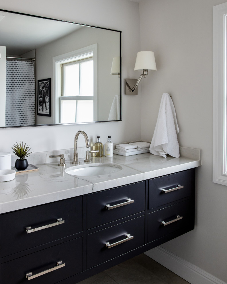 Immagine di una stanza da bagno con doccia chic di medie dimensioni con ante lisce, ante nere, pareti grigie, lavabo sottopiano, pavimento marrone, top grigio, un lavabo e mobile bagno sospeso