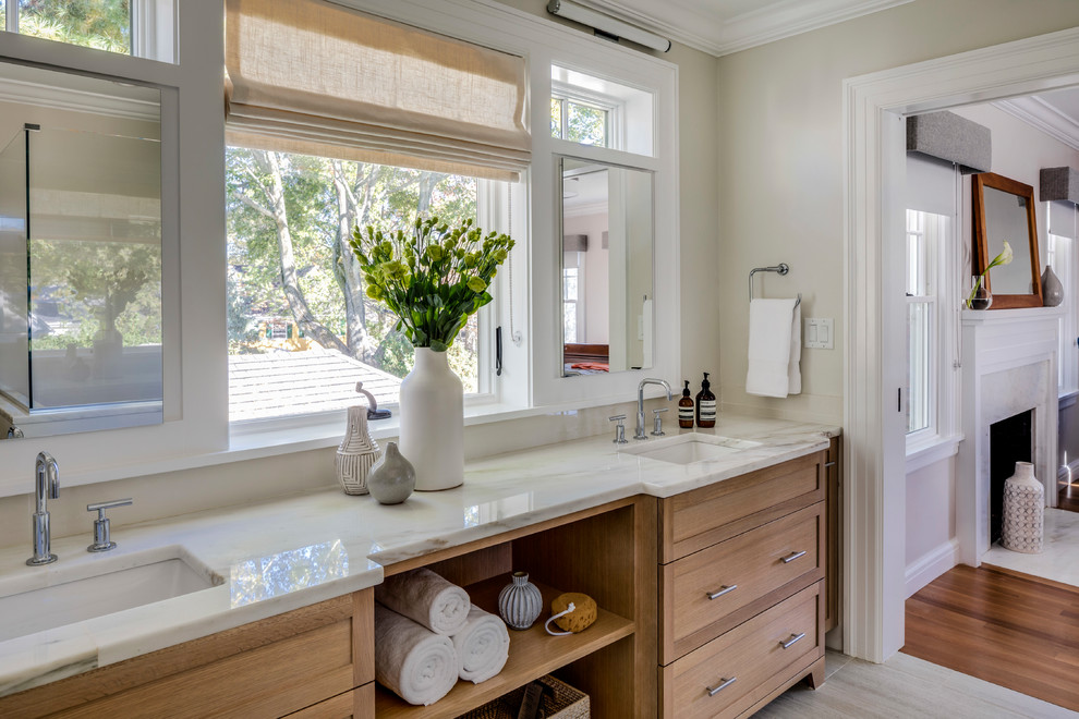 Diseño de cuarto de baño tradicional renovado con armarios estilo shaker, puertas de armario de madera oscura, paredes beige, aseo y ducha, lavabo bajoencimera y suelo gris