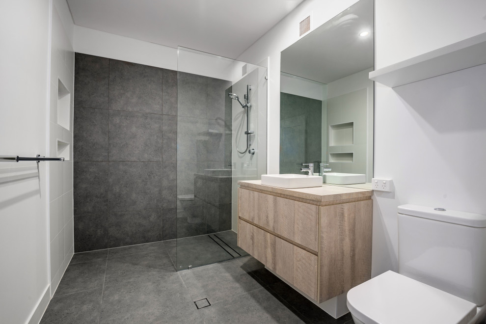 Пример оригинального дизайна: детская ванная комната среднего размера в морском стиле с фасадами островного типа, серыми фасадами, открытым душем, унитазом-моноблоком, серой плиткой, керамической плиткой, белыми стенами, полом из керамической плитки, накладной раковиной, столешницей из ламината, серым полом и открытым душем