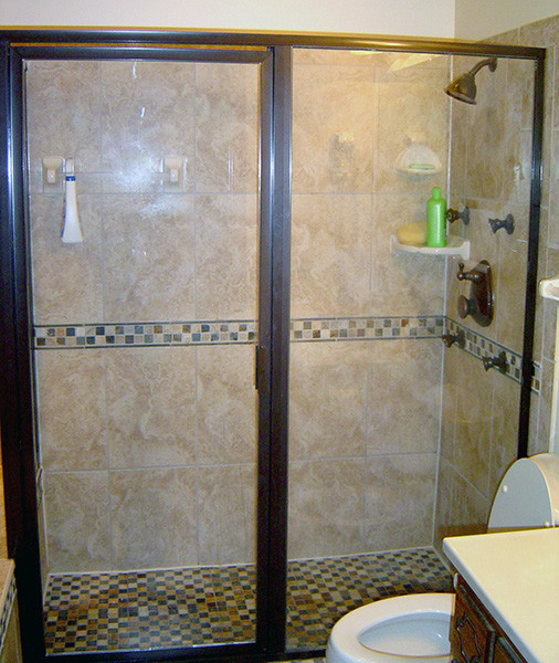 Cette image montre une petite salle de bain méditerranéenne avec une baignoire posée, un carrelage beige, des carreaux de céramique, un mur beige, un sol en carrelage de céramique, un sol beige et une cabine de douche à porte battante.