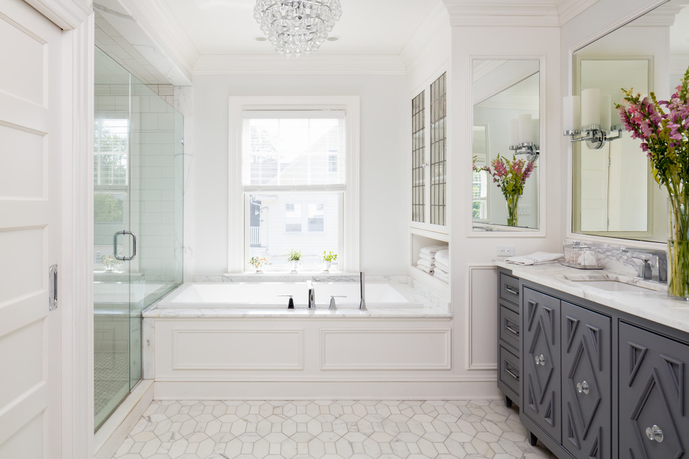 Inredning av ett klassiskt en-suite badrum, med luckor med infälld panel, grå skåp, ett platsbyggt badkar, en dusch i en alkov, vit kakel, vita väggar, ett undermonterad handfat, vitt golv och dusch med gångjärnsdörr