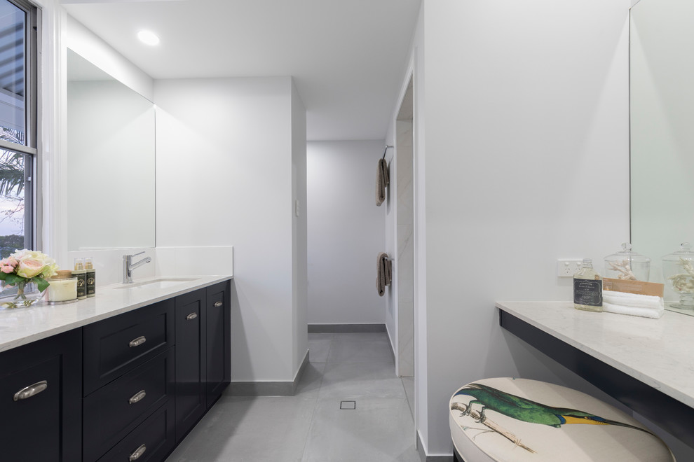 Idéer för att renovera ett mellanstort funkis vit vitt en-suite badrum, med skåp i shakerstil, blå skåp, våtrum, en toalettstol med hel cisternkåpa, vit kakel, keramikplattor, vita väggar, klinkergolv i keramik, ett nedsänkt handfat, granitbänkskiva, grått golv och med dusch som är öppen