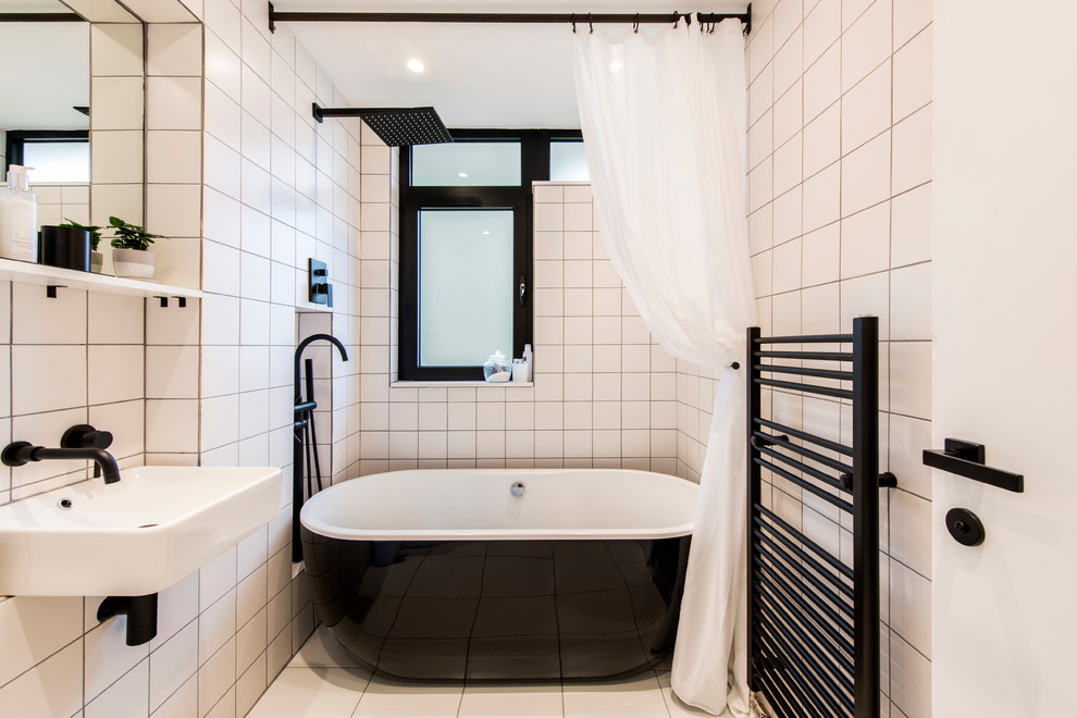 Foto på ett litet funkis badrum för barn, med öppna hyllor, ett fristående badkar, en dusch/badkar-kombination, vit kakel, porslinskakel, klinkergolv i porslin, ett väggmonterat handfat, vitt golv, dusch med duschdraperi och vita väggar