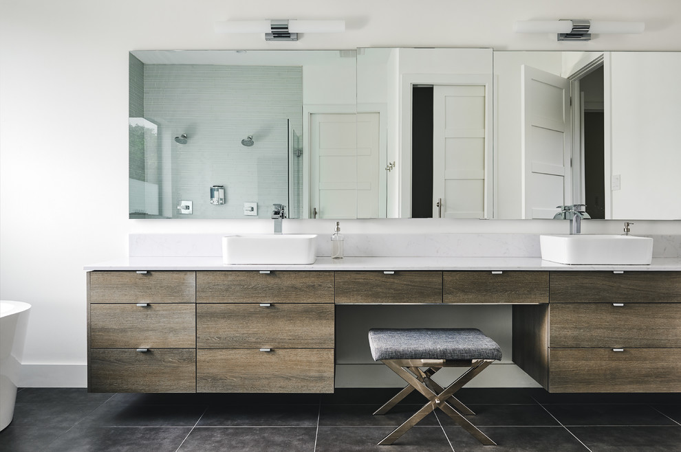 Example of a mid-sized minimalist master gray tile and subway tile porcelain tile and gray floor bathroom design in Dallas with flat-panel cabinets, medium tone wood cabinets, a one-piece toilet, white walls, a vessel sink, quartz countertops, a hinged shower door and white countertops