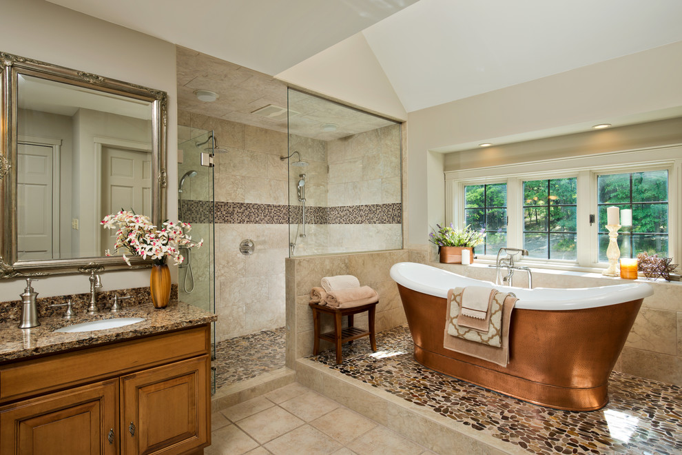 Example of a large classic master beige tile and pebble tile pebble tile floor bathroom design in Boston with raised-panel cabinets, medium tone wood cabinets, beige walls, an undermount sink and quartz countertops