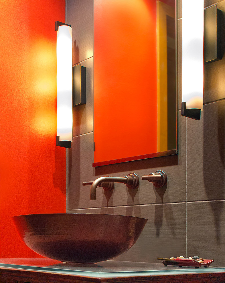 Пример оригинального дизайна: маленькая ванная комната в современном стиле с красными фасадами, открытым душем, унитазом-моноблоком, серой плиткой, керамогранитной плиткой, оранжевыми стенами, полом из керамогранита, настольной раковиной, стеклянной столешницей, фасадами островного типа и душевой кабиной для на участке и в саду