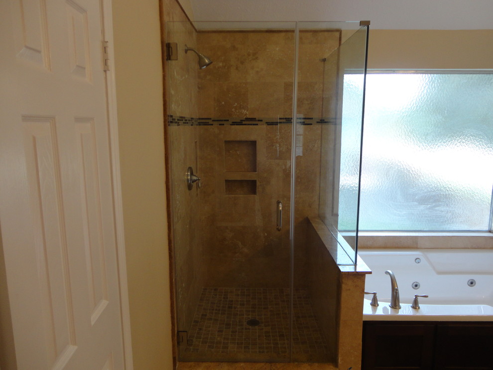 Cette image montre une grande salle de bain principale design avec un lavabo encastré, un placard à porte shaker, des portes de placard marrons, un plan de toilette en granite, un bain bouillonnant, une douche d'angle, WC séparés, un carrelage beige, un carrelage de pierre, un mur beige et un sol en travertin.