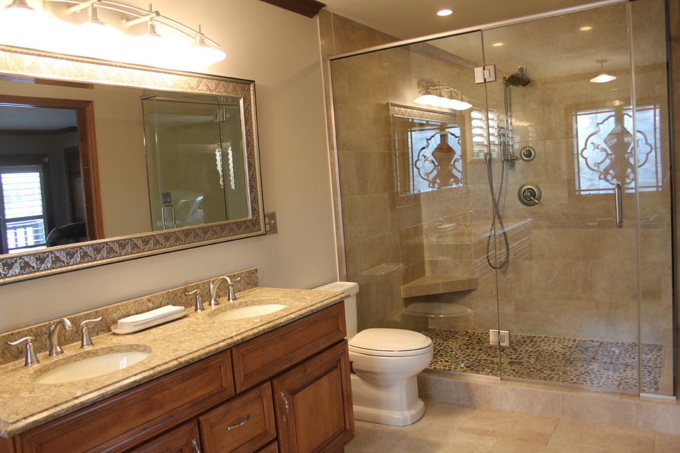 Idées déco pour une salle de bain classique en bois brun de taille moyenne avec un placard avec porte à panneau surélevé, WC séparés, un carrelage beige, un carrelage de pierre, un mur beige, un sol en calcaire, un lavabo encastré, un plan de toilette en granite et un sol beige.
