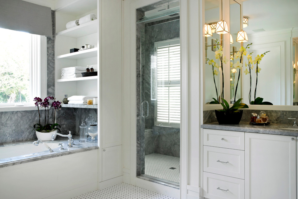 Exemple d'une grande salle de bain bord de mer avec une baignoire d'angle, une douche d'angle, un mur gris, un sol en carrelage de céramique, un lavabo encastré, un sol blanc et une cabine de douche à porte battante.