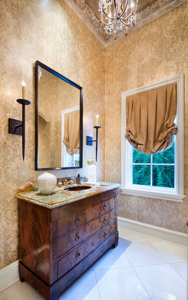 Ispirazione per una stanza da bagno mediterranea con lavabo sottopiano, ante in legno bruno, pareti beige e ante lisce
