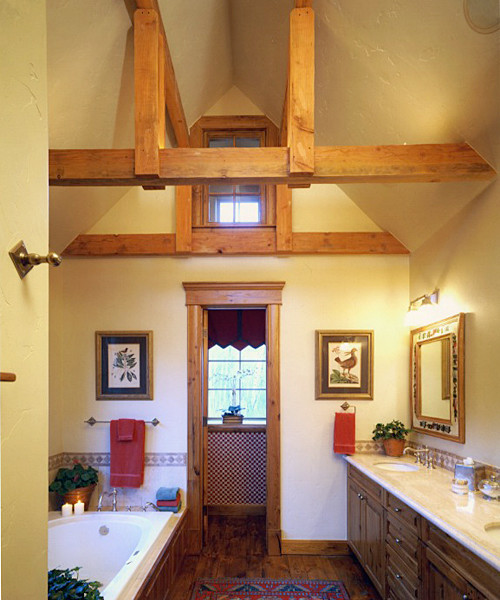 Esempio di una stanza da bagno stile americano di medie dimensioni con ante con bugna sagomata, ante in legno bruno, vasca da incasso, pareti beige, parquet scuro, lavabo sottopiano e top in granito