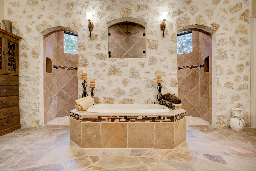 На фото: главная ванная комната в средиземноморском стиле с накладной ванной, открытым душем, бежевыми стенами и открытым душем с